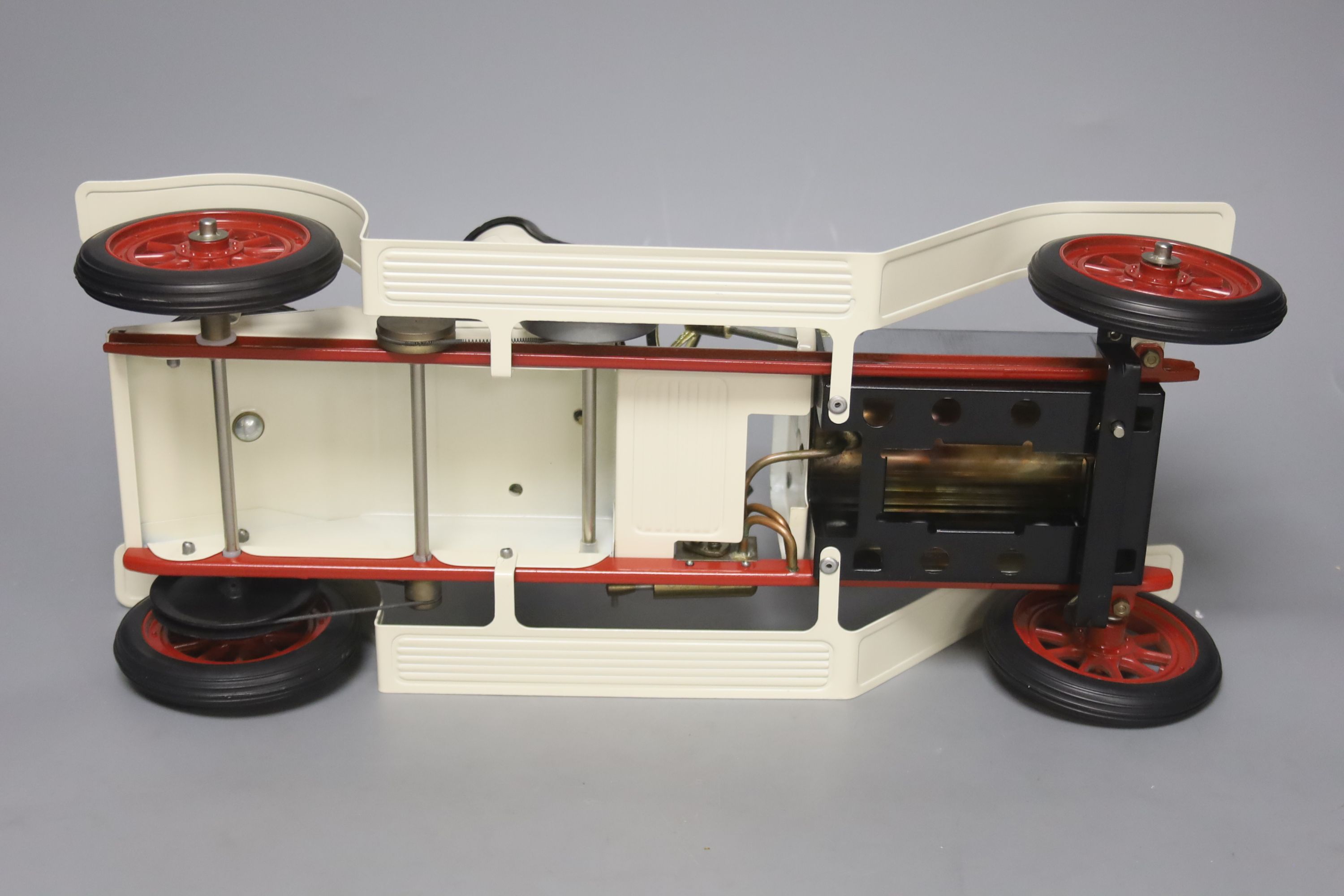 A Mamod live steam vintage two-seater roadster, with silver and cream paintwork and red wheels, oil can